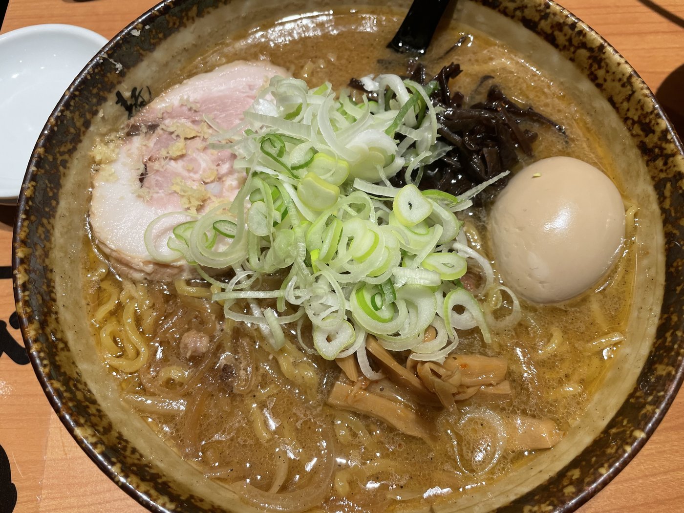 A bowl of rich miso ramen with chashu, egg and green onions