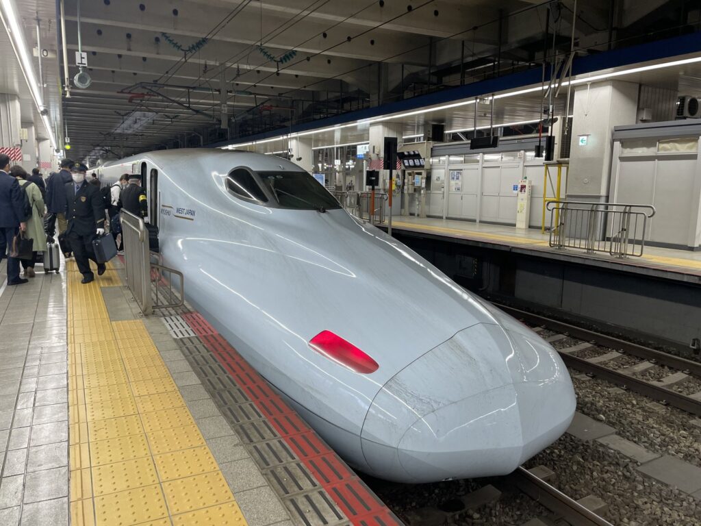 วิธีขึ้นชินคันเซ็น: คู่มือฉบับมือใหม่ (2026) Passengers boarding a Shinkansen bullet train