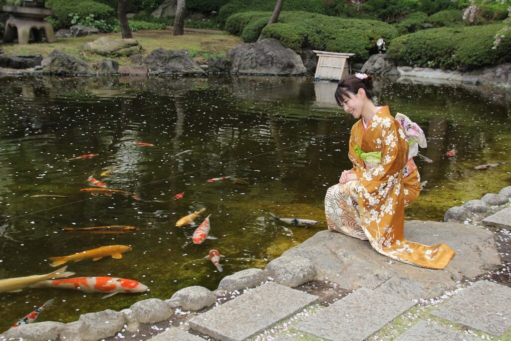 Kimono Explained: History, Types and How to Read One A Japanese woman wearing a Kimono and Koi Fish